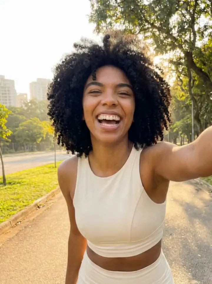 Influenciadora com o conjunto creme CDG fazendo selfie no parque ao amanhecer